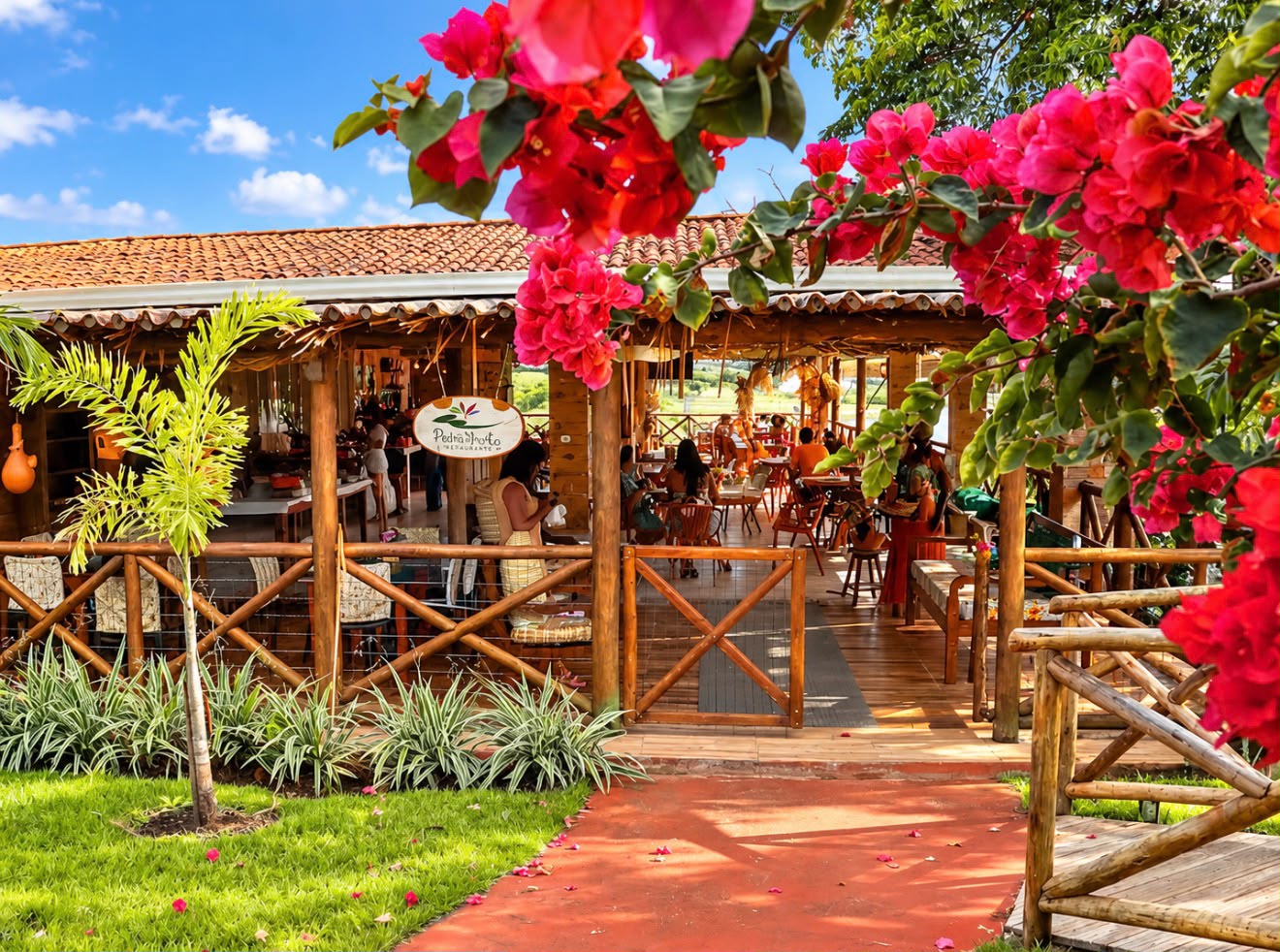 Entrada do restaurante Pedra Bonita entre flores