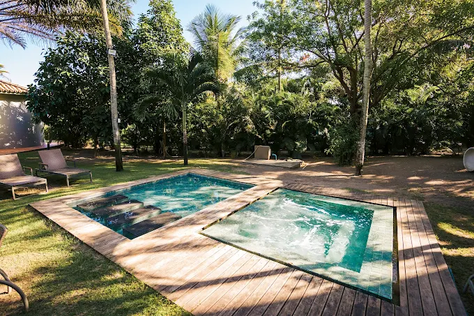 Piscina com deck de madeira em meio à natureza