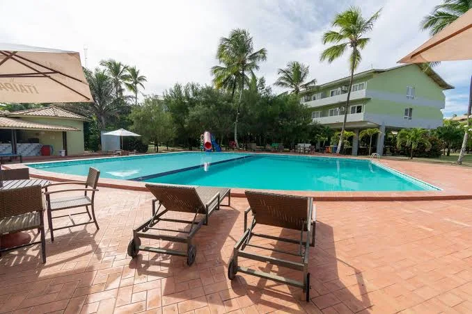 Piscina principal do resort com coqueiros